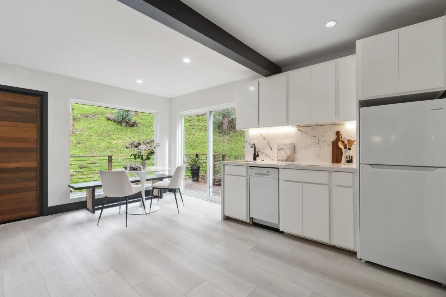 Modern kitchen with white cabinetry and garden views
