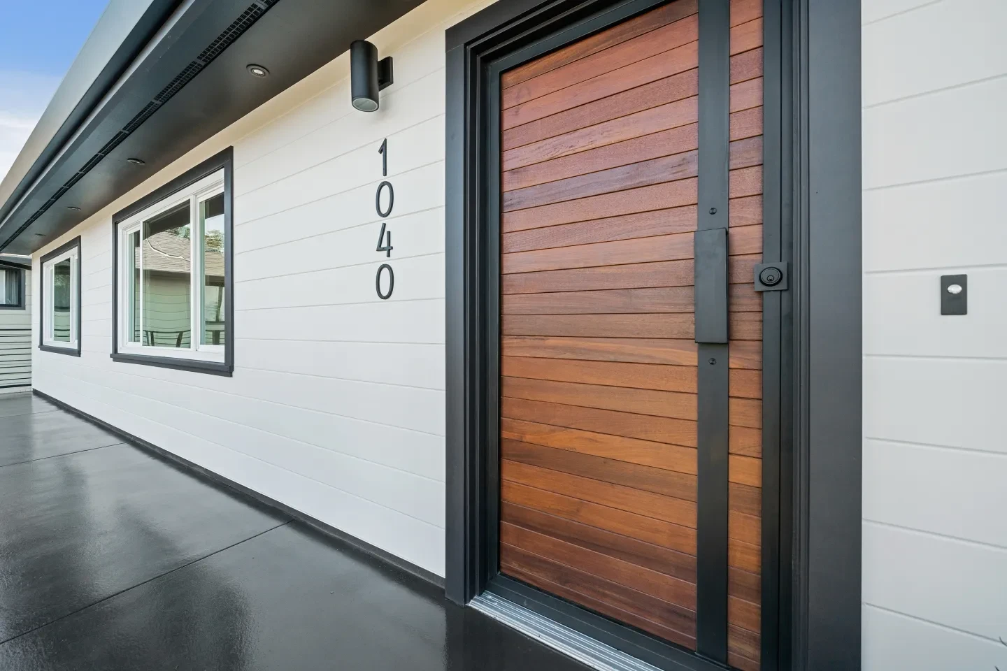 Modern home entryway with wood door and address numbers