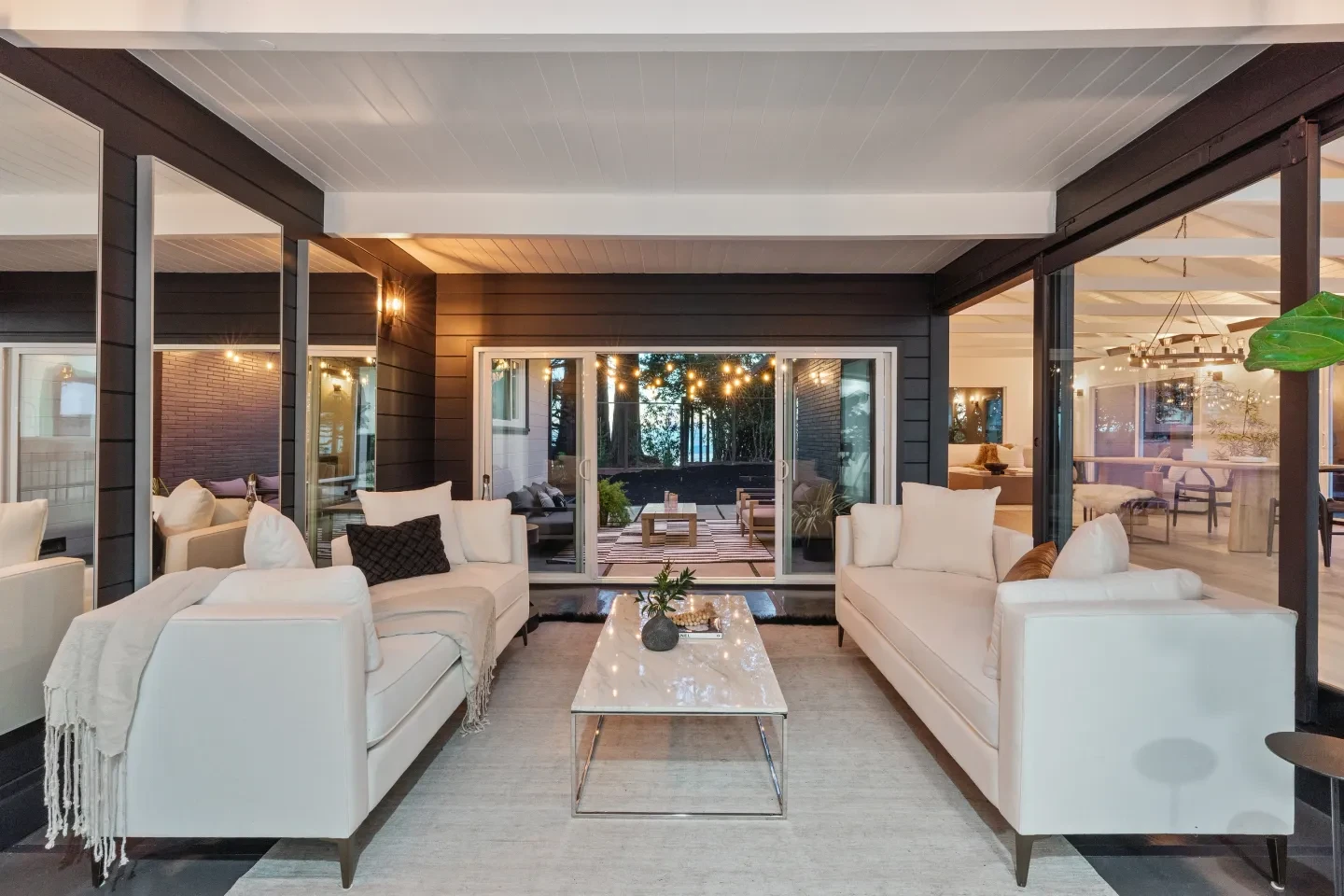 Modern living room with white sofas and patio views
