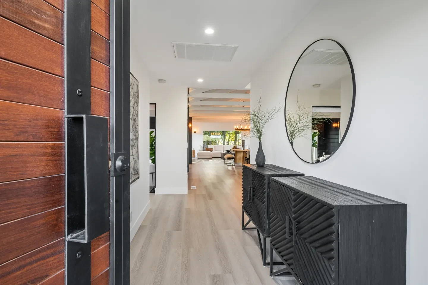 Modern entryway hallway with wood door and oval mirror