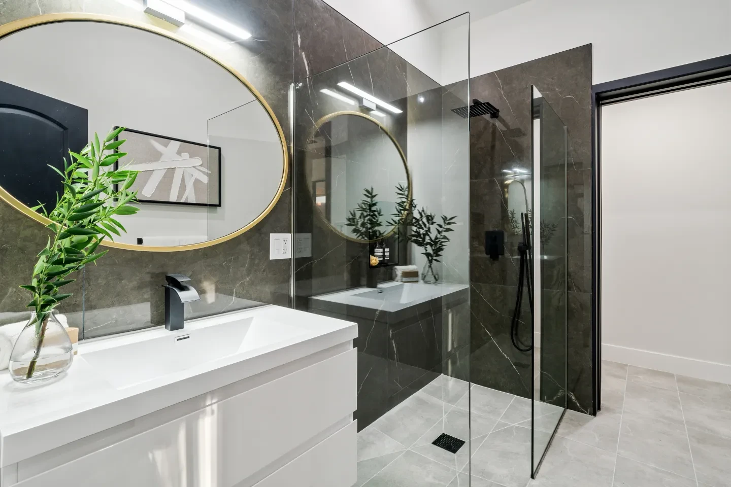Luxury bathroom with dark marble tile and gold round mirror