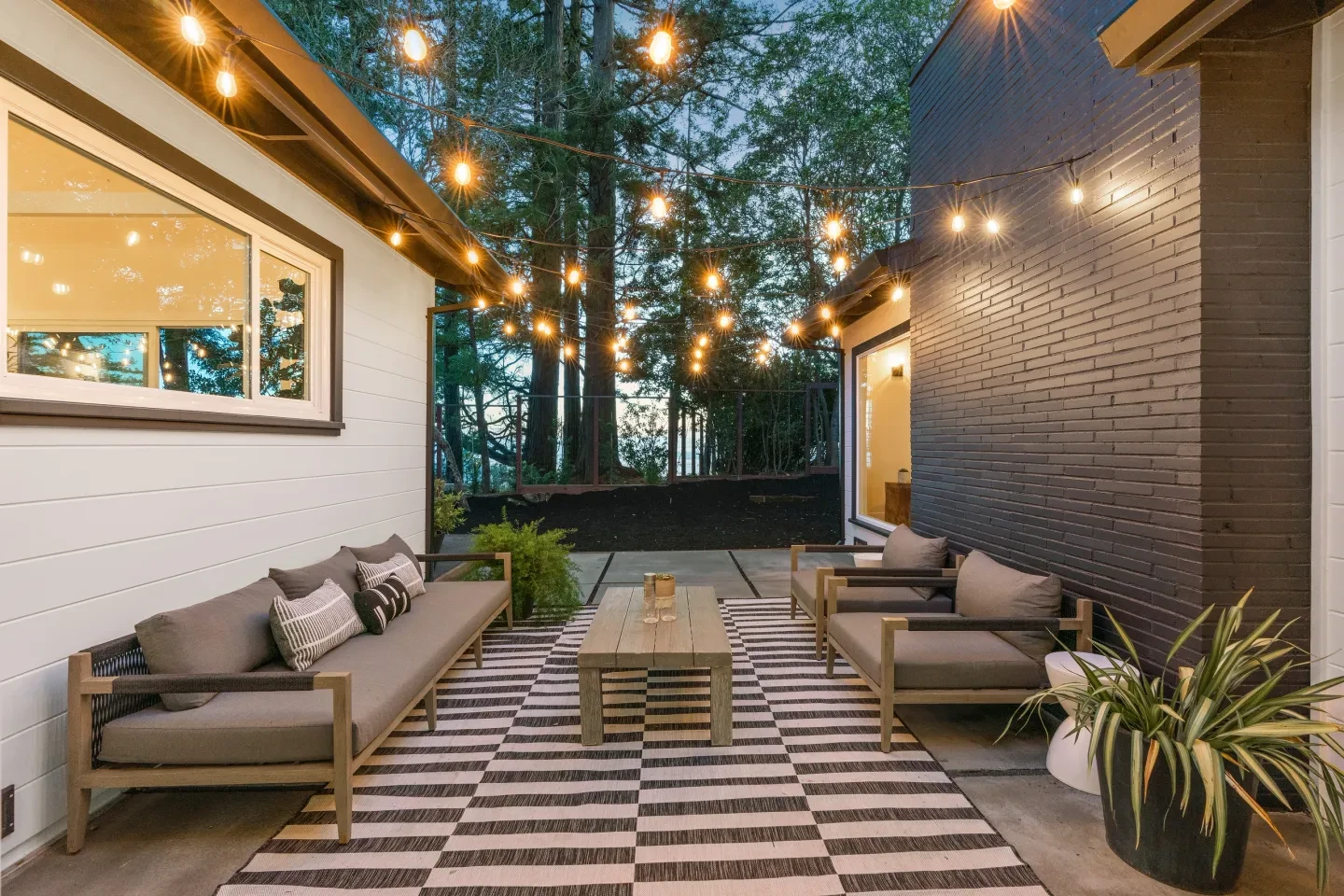 Modern outdoor patio with string lighting and contemporary furniture