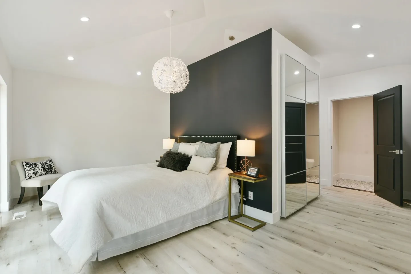 Modern bedroom with dark accent wall and globe pendant light