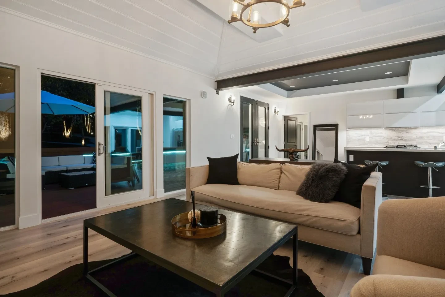 Modern living room at night with sofa and open patio doors