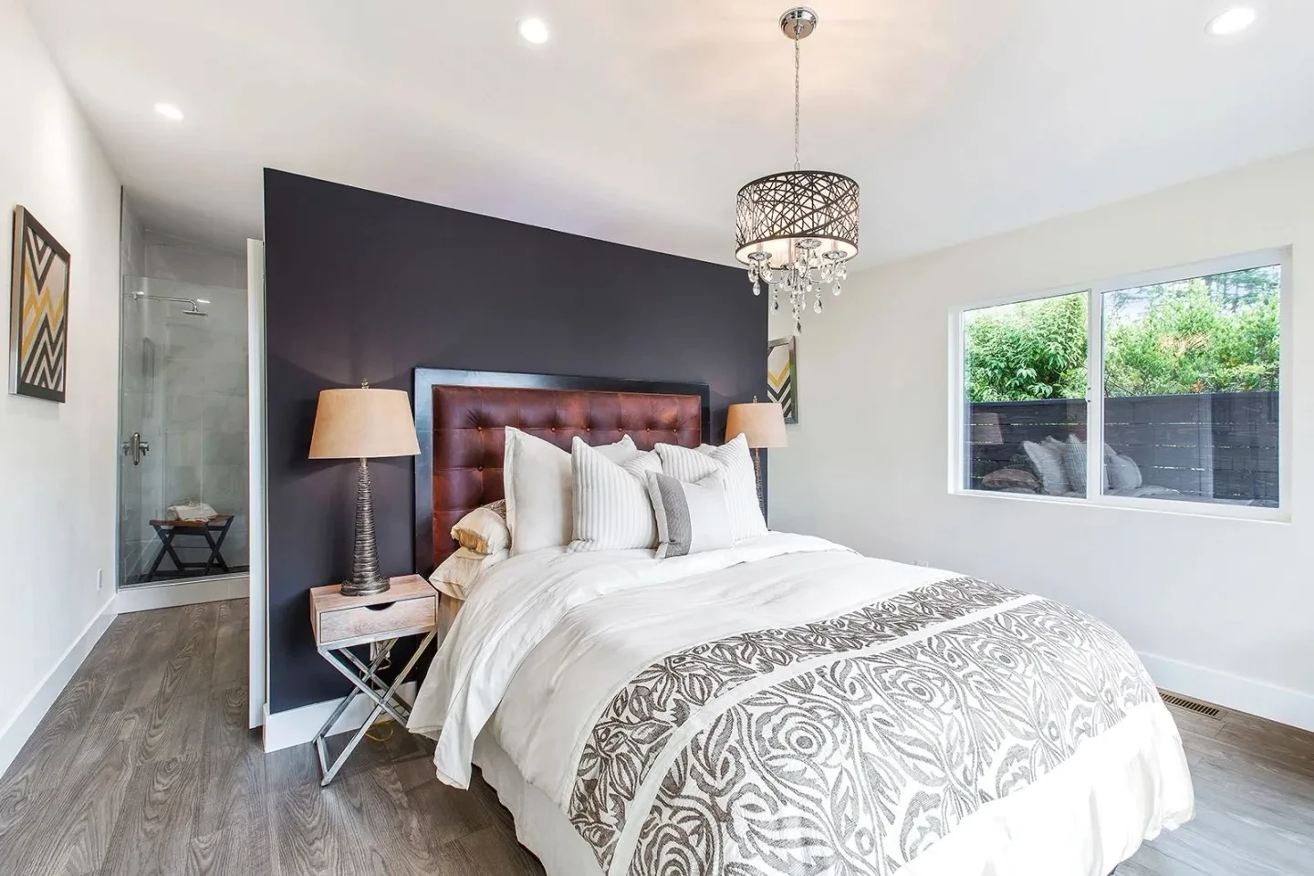 Modern bedroom with dark accent wall and burgundy headboard