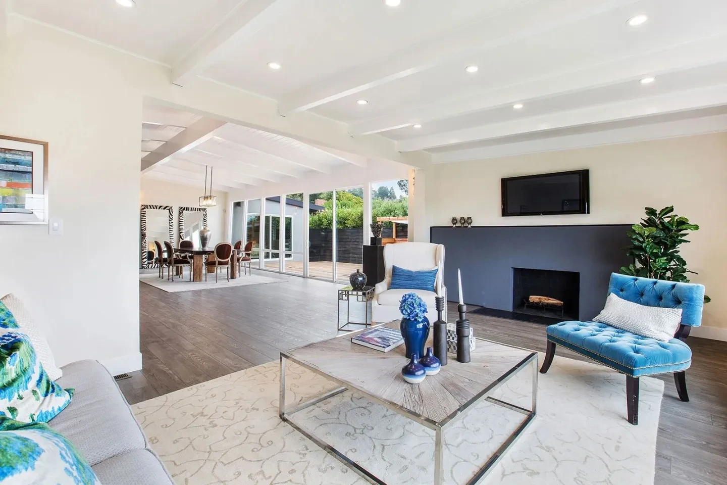 Modern living room with blue accent chairs and fireplace