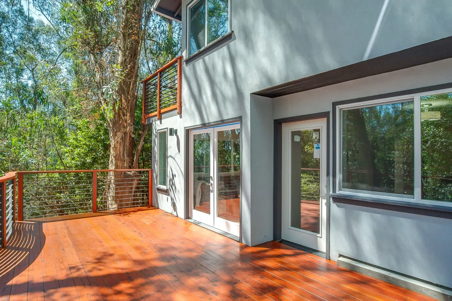 Modern residential deck with warm wood tones and metal railings