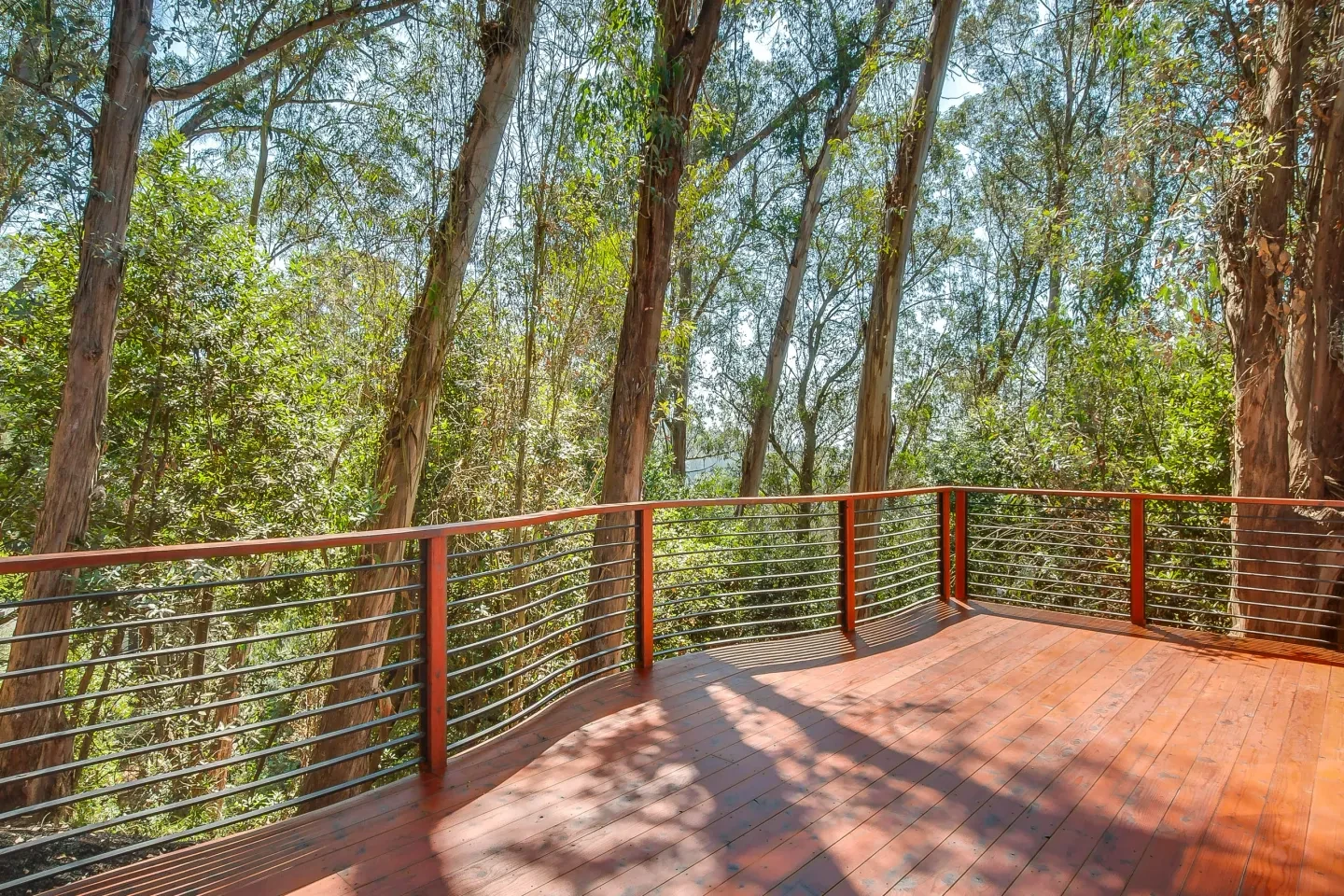 Wooden deck overlooking forest canopy with warm wood tones