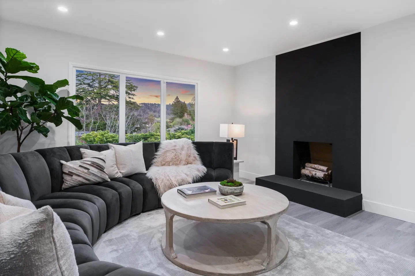 Modern living room with black curved sofa and fireplace